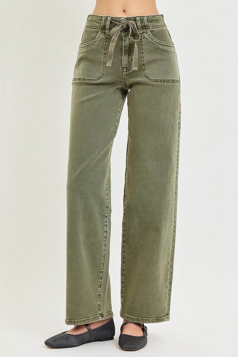 Olive green wide-leg jeans with a drawstring waist, modeled from the waist down with black flats on a light gray background.